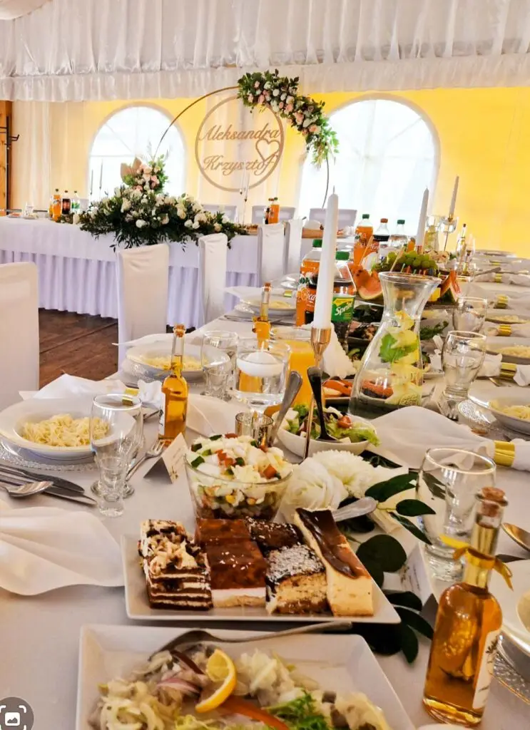 catering weselny Kielce – elegancko nakryty stół z deserami i sałatkami w namiocie bankietowym