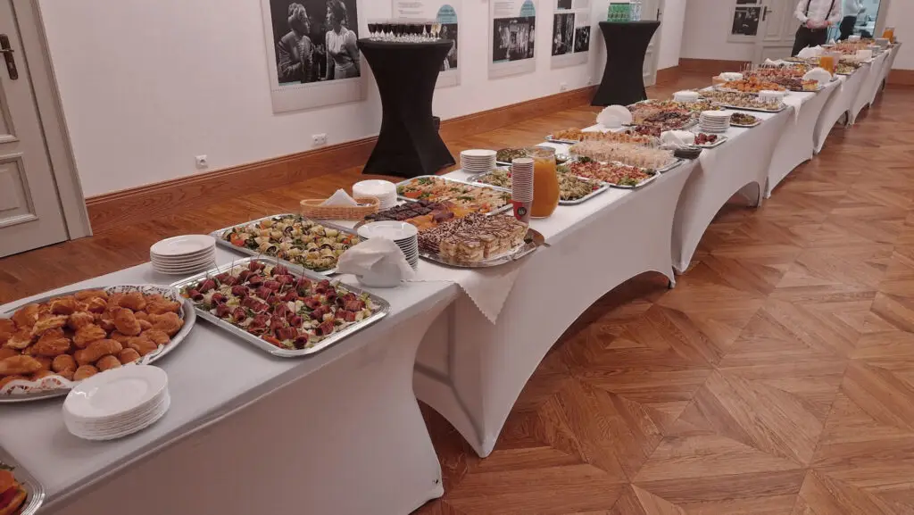 catering firmowy Kielce – długi bufet z przekąskami i deserami podczas eventu biznesowego